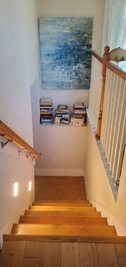 Staircase with bookshelf and abstract painting