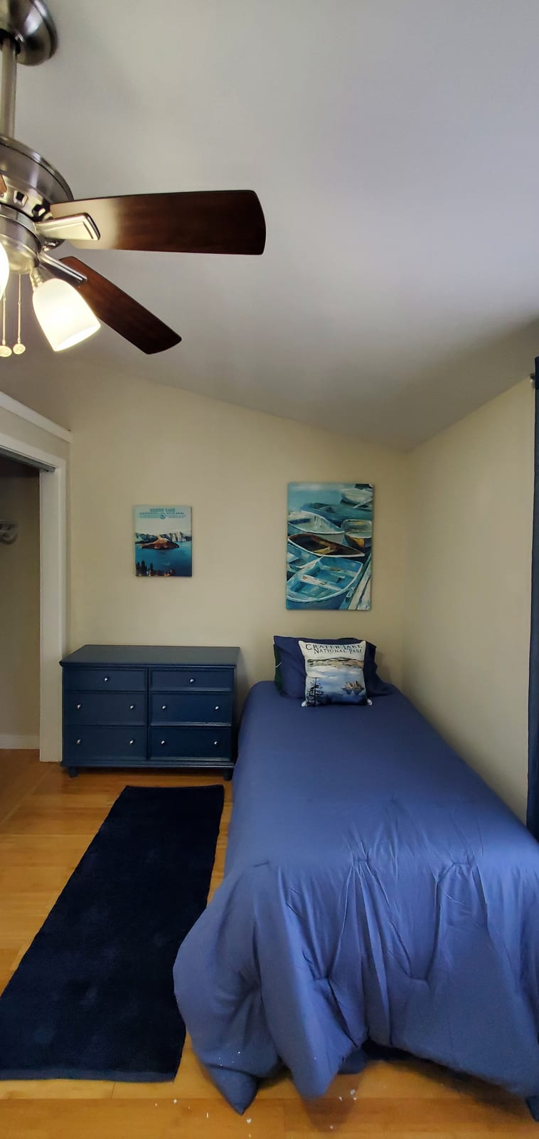 Bedroom with blue bedding and navy dresser