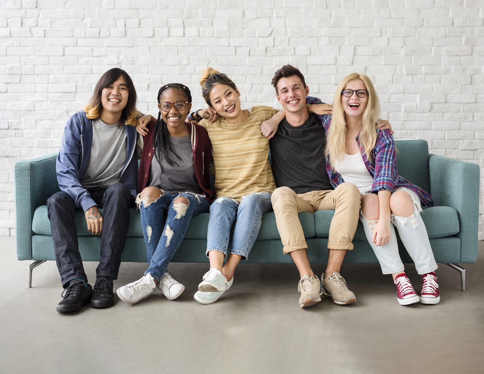 A group of diverse, smiling young people sitting together